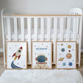 Load image into Gallery viewer, Set of three prints showing rocket, personalised astronaut and planets, beside cot display
