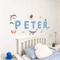 Load image into Gallery viewer, Close view of personalised name fabric wall stickers featuring blue bubble-effect letters and sea creatures