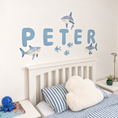 Load image into Gallery viewer, Close view of personalised name fabric wall stickers featuring blue bubble-effect letters with sharks and fish