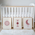 Load image into Gallery viewer, Set of three prints showing rose red sun, moon phases and crescent moon with stars, beside cot display
