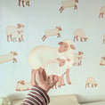 Load image into Gallery viewer, Close-up of a sheep and lamb fabric wall sticker held against a nursery wall