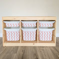 Load image into Gallery viewer, A wooden shelf with six compartments, each containing a white plastic bin with a pink and white striped pattern.
