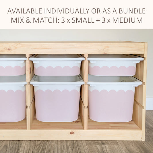 a wooden storage unit with multiple pink plastic bins arranged inside it. The bins are of varying sizes, and the storage unit appears to be made of wood.
