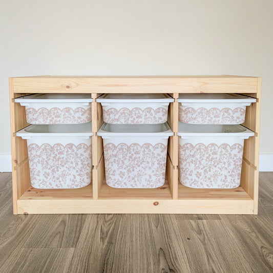 A wooden shelf with six white storage bins arranged in two rows of three, each bin with a floral pattern.