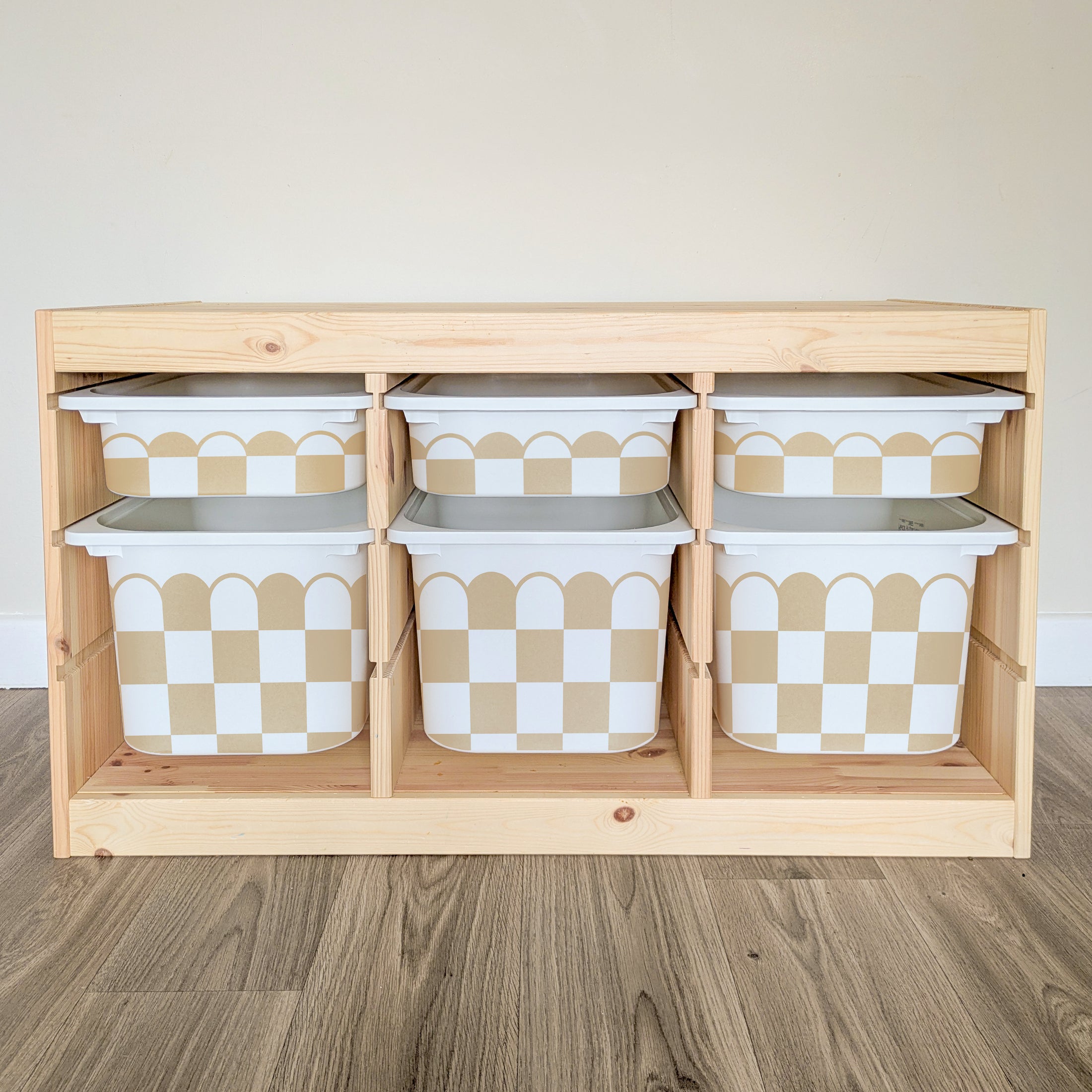 A wooden shelf with six white and tan checkered storage bins arranged in two rows of three.