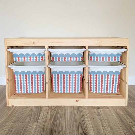 A wooden shelf with six storage bins on it, each with a pattern of red, white, and blue stripes.