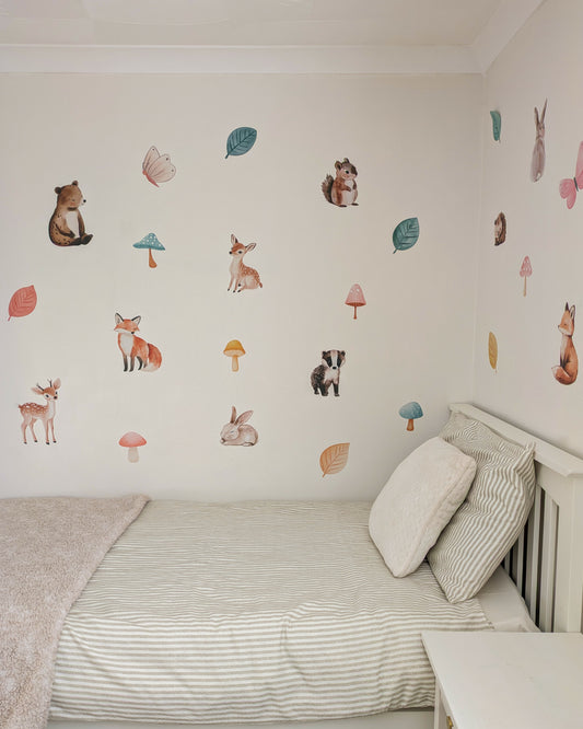 Children's bedroom with wall stickers of animals and nature on a white wall.