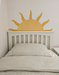 Load image into Gallery viewer, Bed with a sun-shaped wall decal above it in a minimalistic room.
