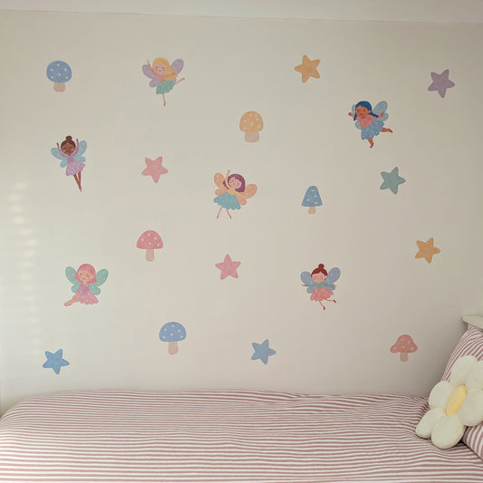 Wall with fairy and mushroom wall stickers above a bed.