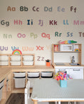 Load image into Gallery viewer, Pastel alphabet wall stickers in capitals and lowercase on a playroom wall.
