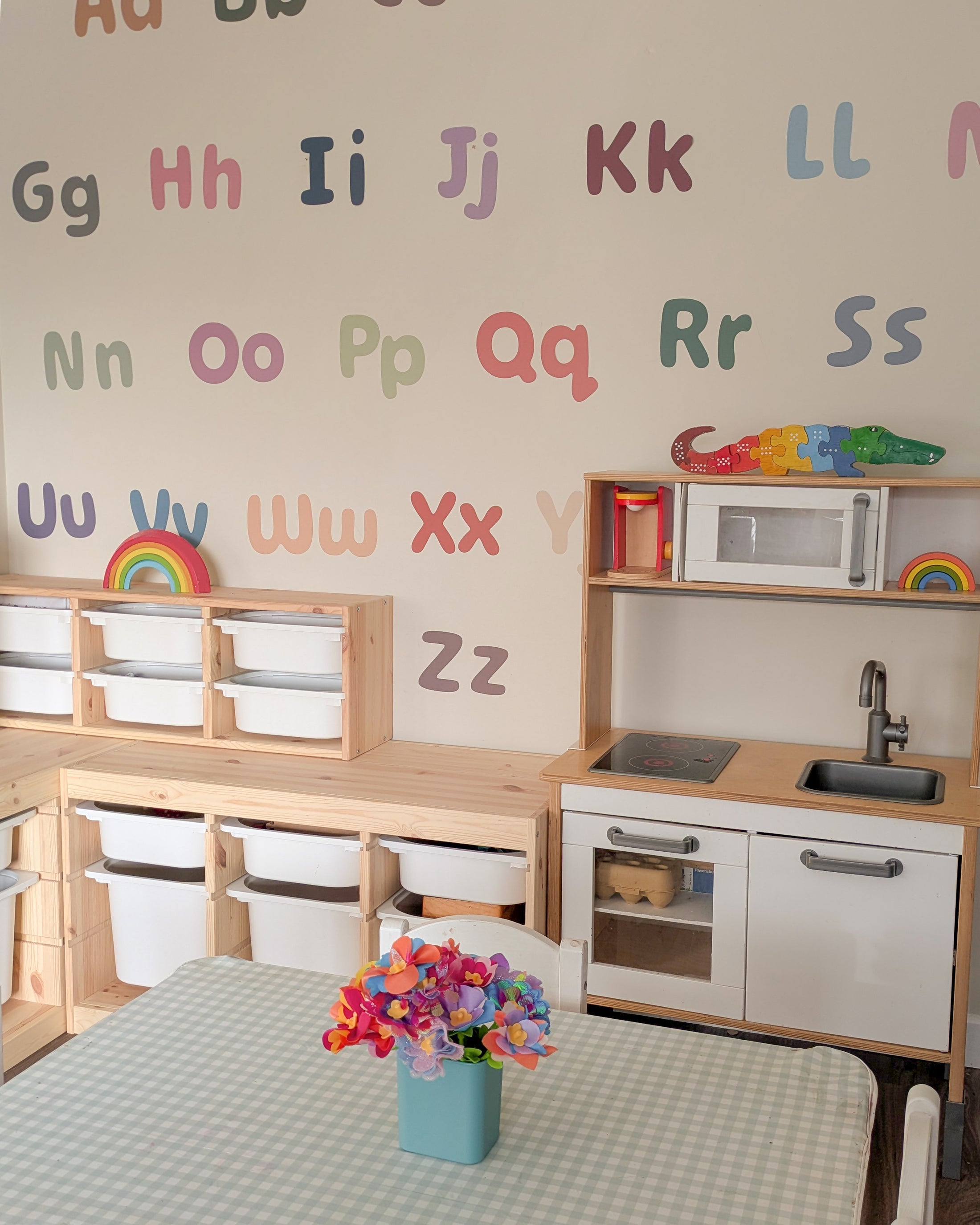 Removable A–Z fabric letter decals arranged above Montessori shelves.