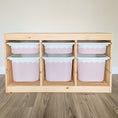 Load image into Gallery viewer, A wooden storage unit with six pink and white storage bins arranged in two rows of three.
