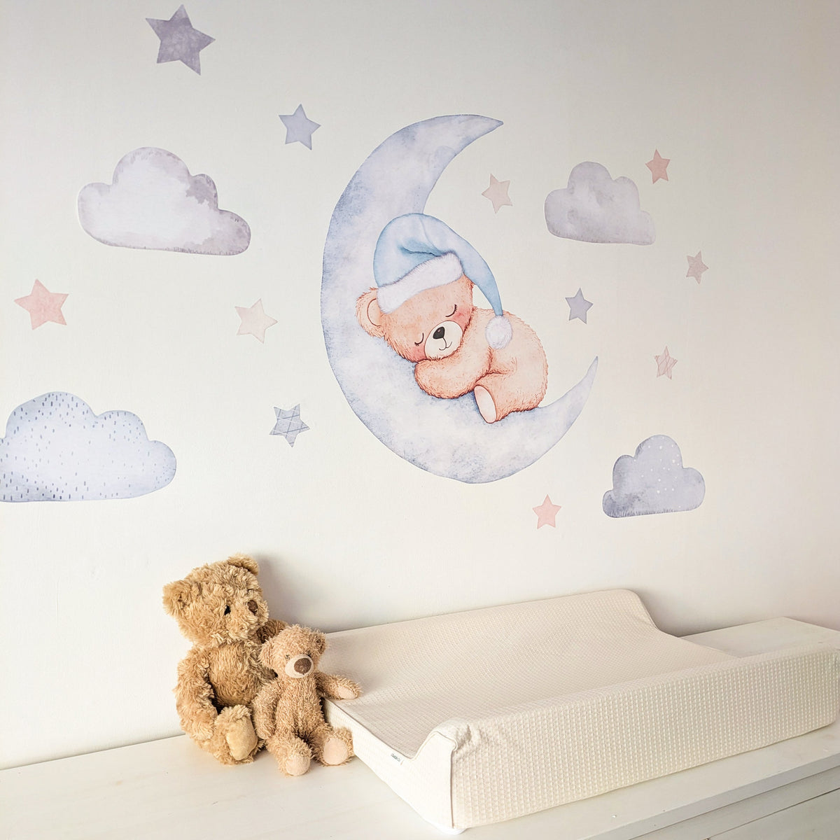 Side view of blue teddy moon wall stickers beside a nursery changing mat