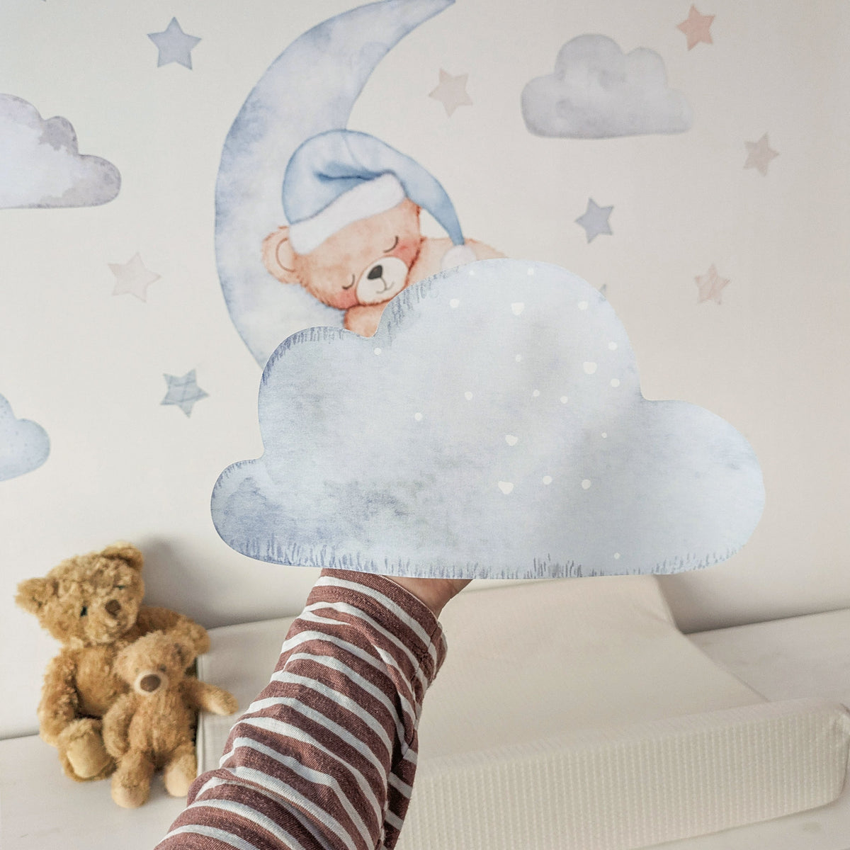 Close-up of a blue cloud fabric wall sticker held against the nursery wall