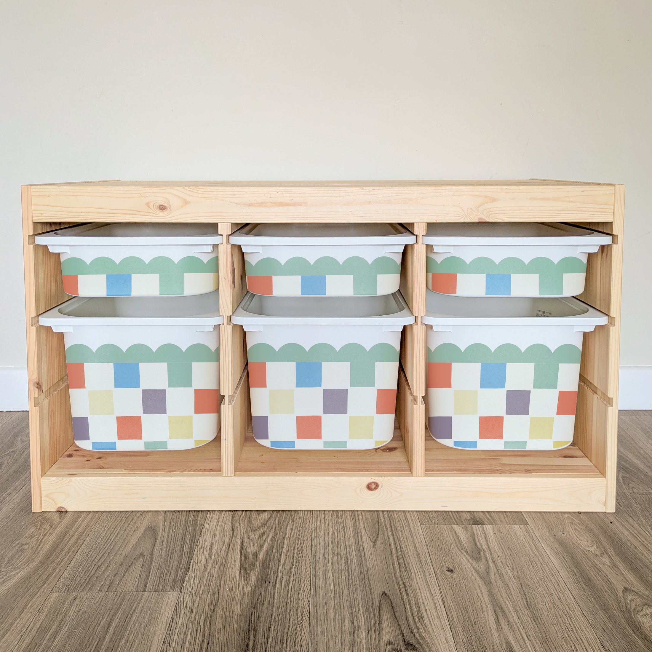 A wooden shelf with six colorful storage bins arranged on it.