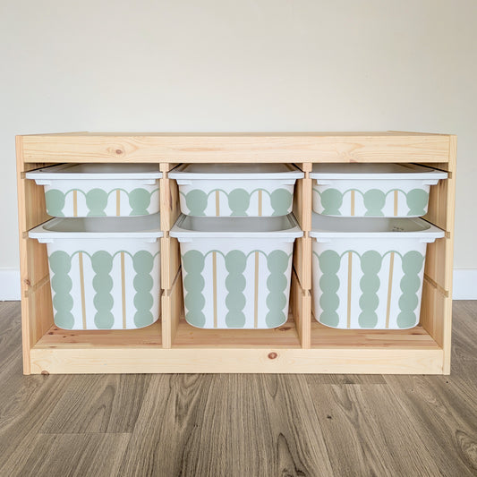 A wooden shelf with six drawers, each containing a white and green patterned storage container.