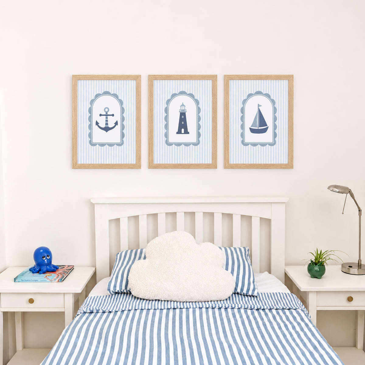 Coastal nursery prints above a bed with blue striped bedding