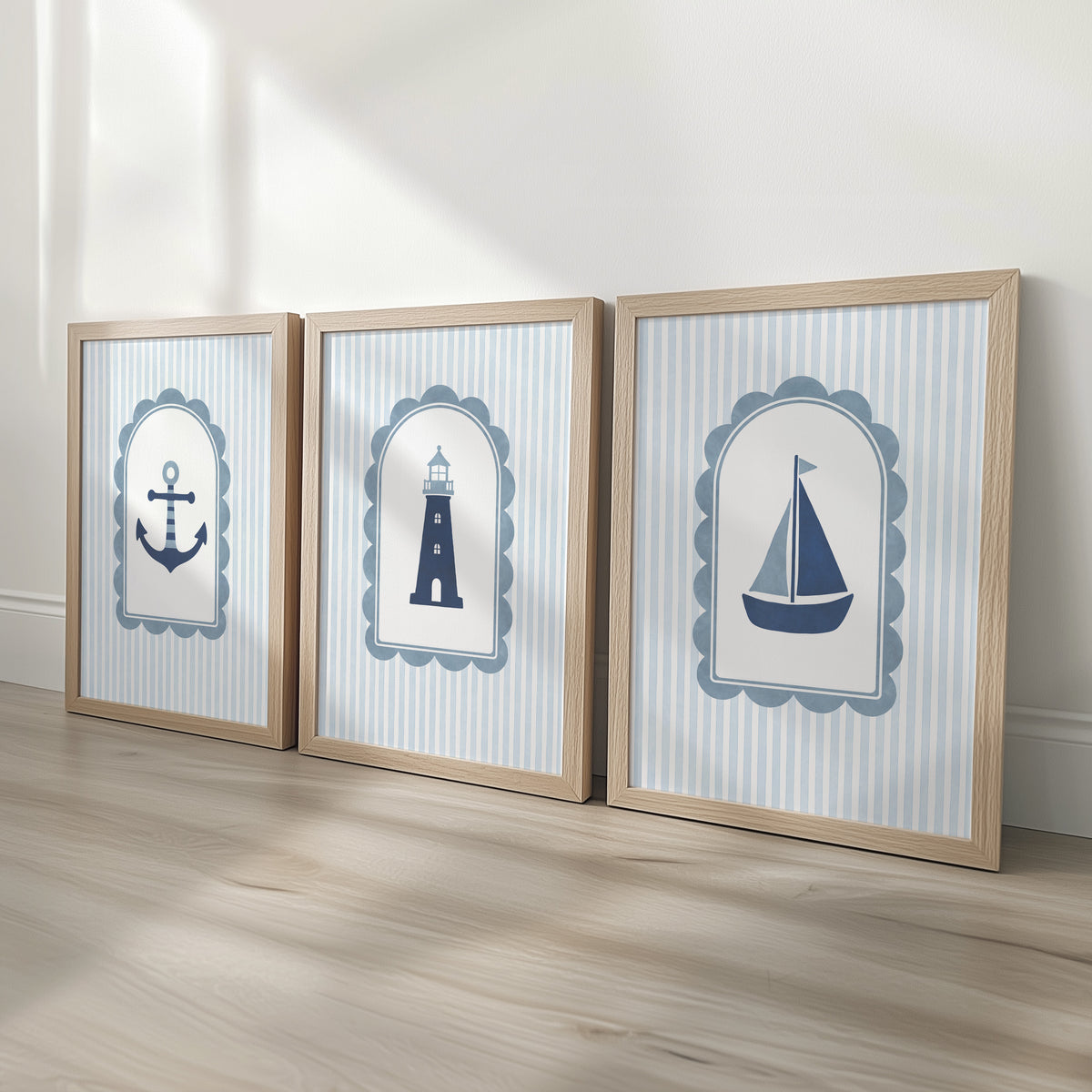 Coastal nursery prints featuring an anchor, lighthouse and sailboat in oak effect frames