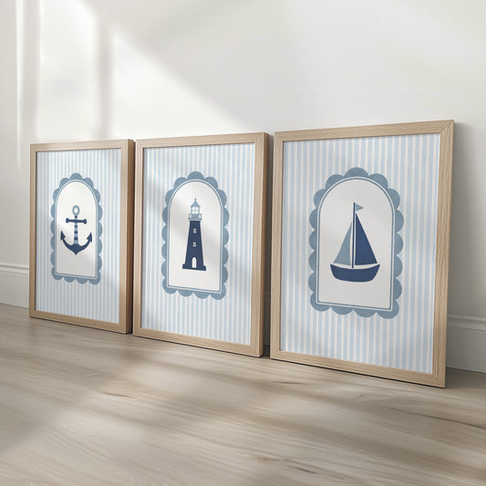 Coastal nursery prints featuring an anchor, lighthouse and sailboat in oak effect frames