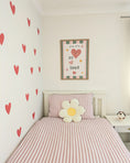 Load image into Gallery viewer, Children's bedroom with pink and white striped bedding, heart wall decals, and a framed picture.
