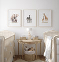 Load image into Gallery viewer, a baby's room with three pictures of animals on the wall
