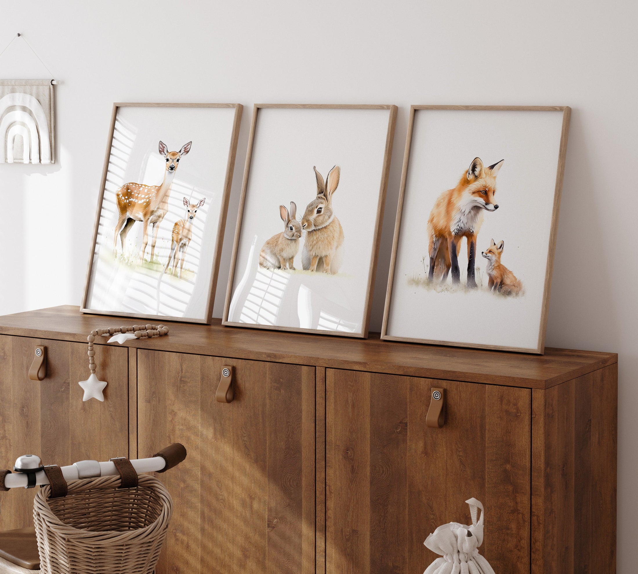 three framed pictures of animals on a wooden cabinet