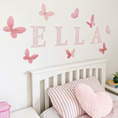 Load image into Gallery viewer, Pink floral ELLA name with butterfly fabric wall stickers above a child's bed
