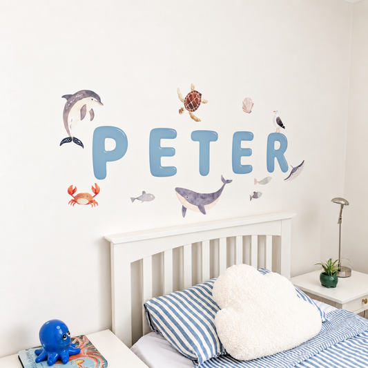 Close view of personalised name fabric wall stickers featuring blue bubble-effect letters and sea creatures