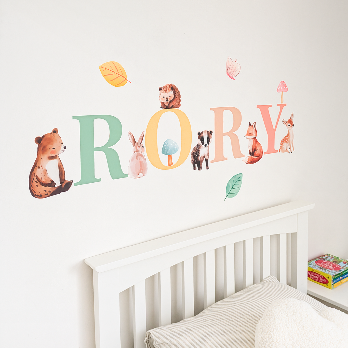 Close view of personalised name fabric wall stickers featuring multicoloured letters with woodland animals and leaves