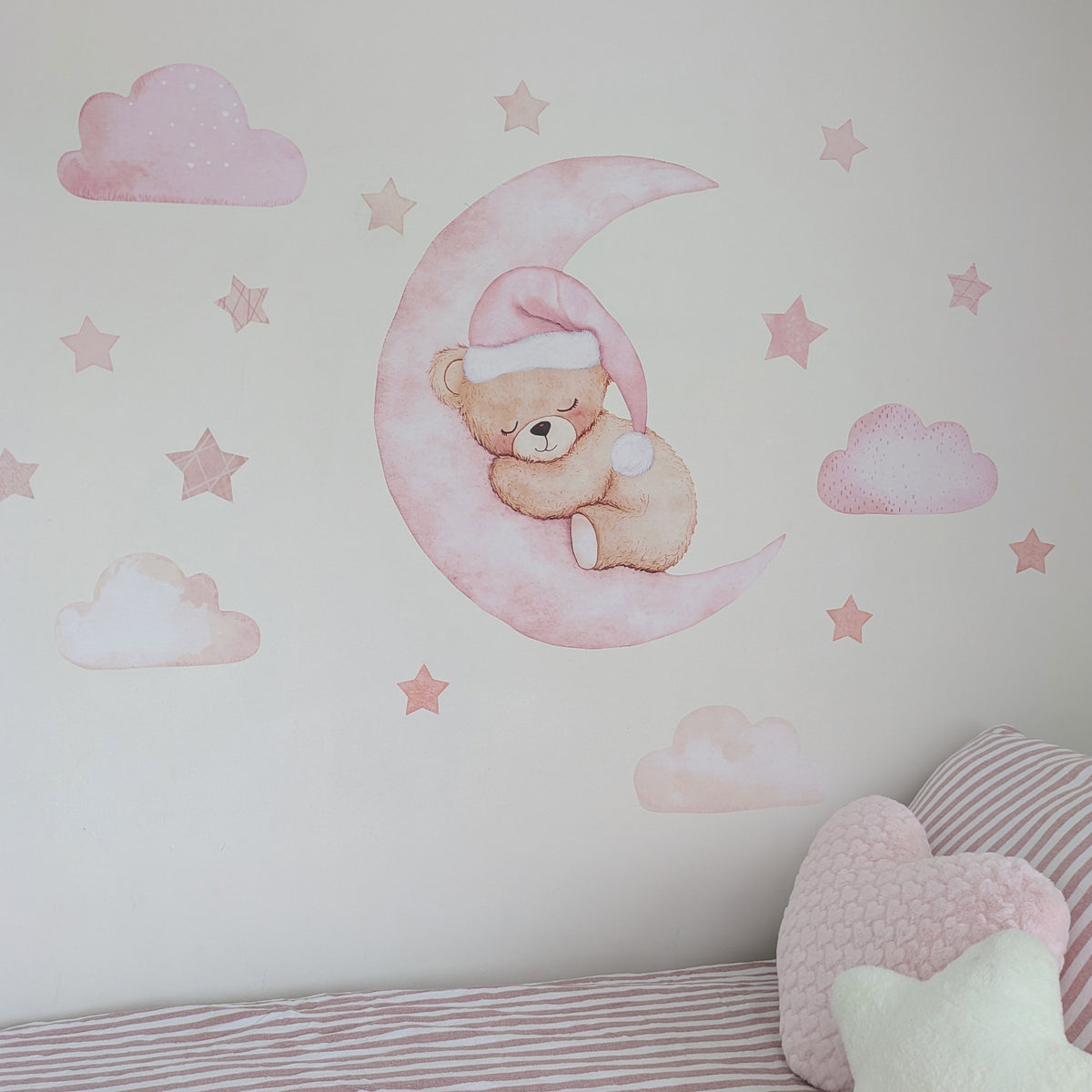 Pink sleeping teddy on a crescent moon with matching clouds and stars