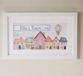 Load image into Gallery viewer, Personalised framed print featuring a charming watercolor design of colourful houses and a hot air balloon in a white frame with mount.
