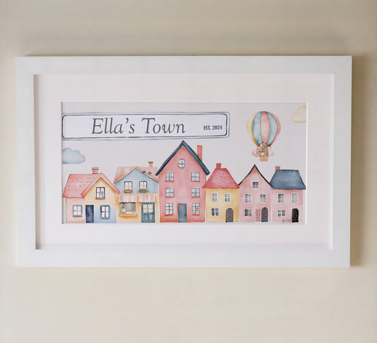 Personalised framed print featuring a charming watercolor design of colourful houses and a hot air balloon in a white frame with mount.