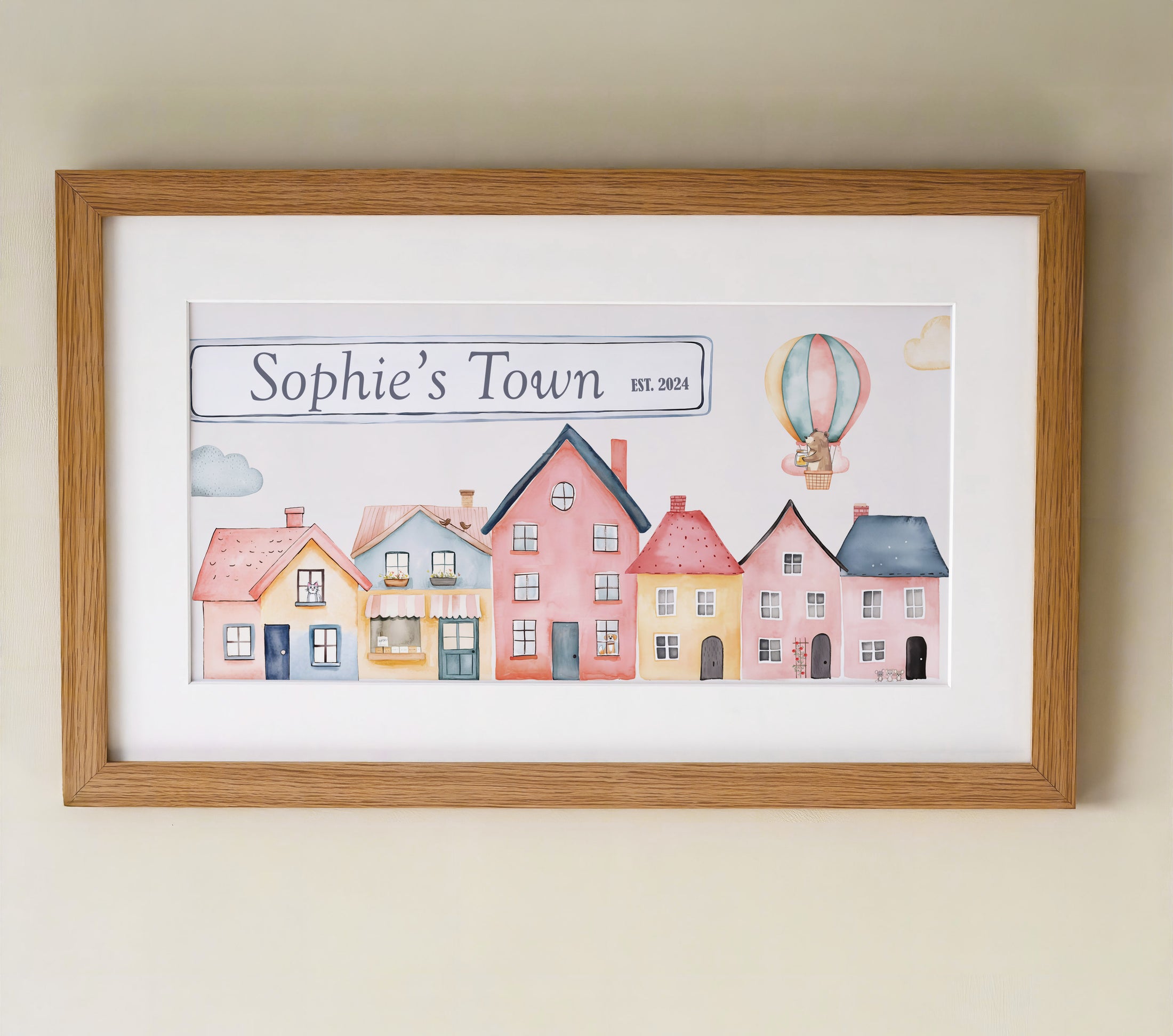Personalised framed print featuring a charming watercolor design of colourful houses and a hot air balloon in a oak frame with mount.