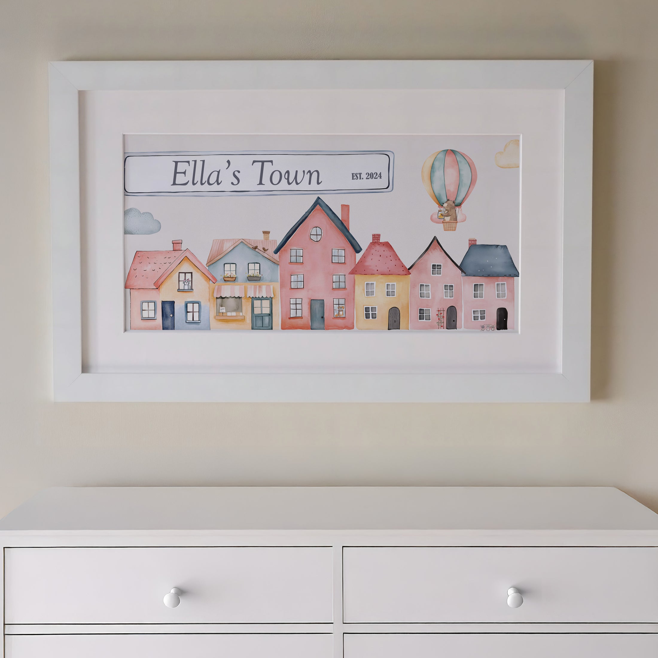 Close-up of personalization details: Close-up of a name and year of birth printed on the Tiny Town artwork in elegant font.