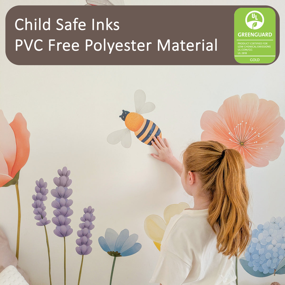 Child placing a bee wall sticker among flowers. Text reads: Child Safe Inks; PVC Free Polyester Material. A GREENGUARD Gold logo is shown.
