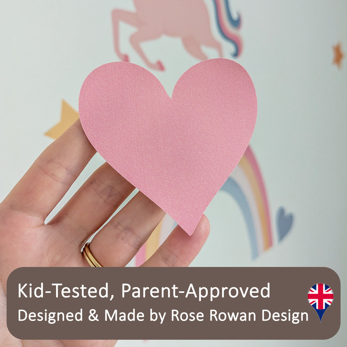 Hand holding a pink heart fabric wall sticker to show its woven texture. Text reads: Kid-Tested, Parent-Approved; Designed & Made by Rose Rowan Design, with a UK flag.