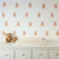 Load image into Gallery viewer, Twenty-one mini teddy bear fabric wall stickers arranged above a nursery changing table
