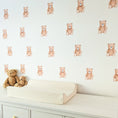 Load image into Gallery viewer, Side view of mini teddy wall stickers arranged in four rows above a changing table
